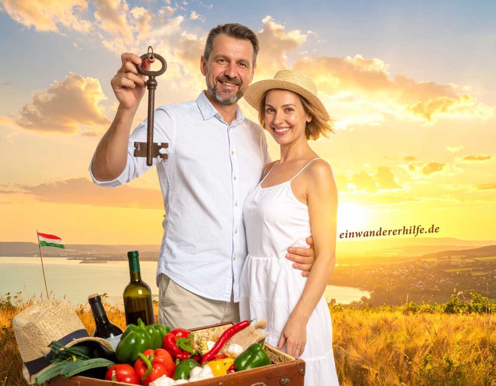 Lächelndes Paar mit großem Schlüssel vor ungarischer Landschaft, Picknickkorb mit Gemüse und Wein im Vordergrund – Symbol für Neustart beim Auswandern nach Ungarn