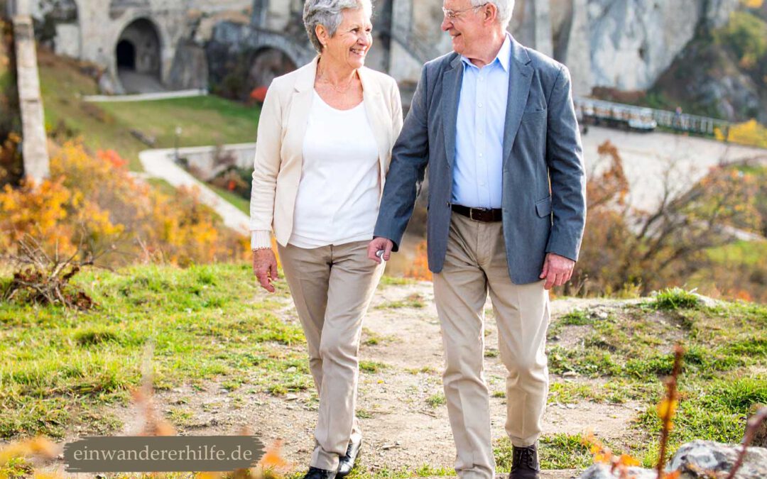 Älteres deutsches Ehepaar spaziert lächelnd Hand in Hand durch die Landschaft bei Morahalom in Ungarn – Sinnbild für Ruhe, Lebensfreude und einen harmonischen Ruhestand.