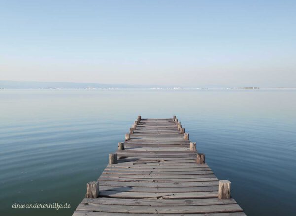 Holzsteg, der in den ruhigen Balaton hinausführt, symbolischer Blick in die Weite für Auswanderer nach Ungarn im Komitat Somogy
